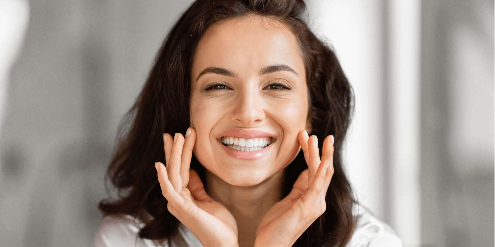 youngish woman smiling with hands at sides of face vascular treatments